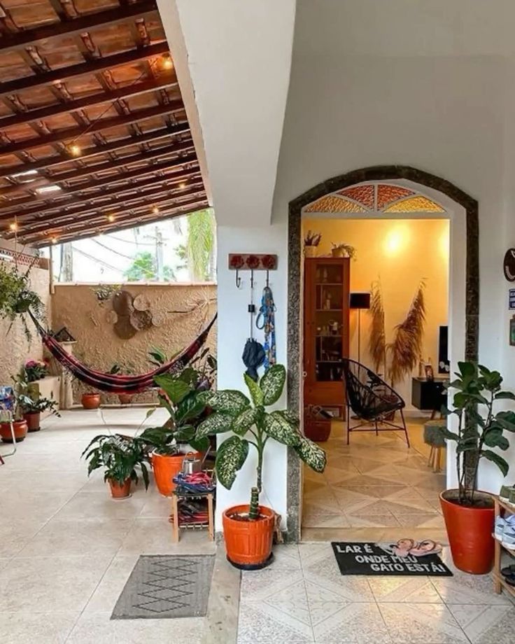 Varanda coberta com rede, plantas e luzes penduradas ao anoitecer