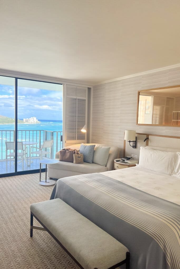 Quarto de pousada com cama montada e varanda aberta para o mar