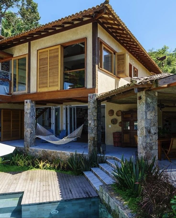 Pousada rústica de dois pisos com piscina, deque de madeira e jardim